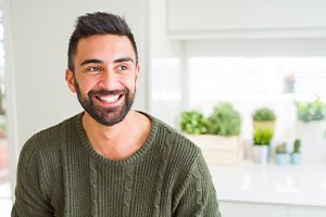 Man in green shirt smiling at home