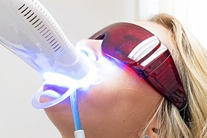 Blonde woman having professional teeth whitening performed