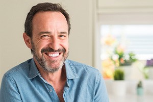 Man in denim shirt at home smiling