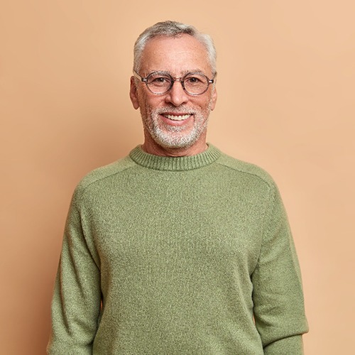 Portrait of smiling senior man in green sweater