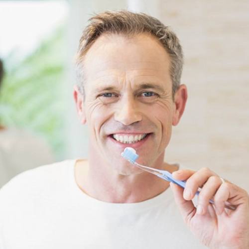 a man preparing to brush his dental implants