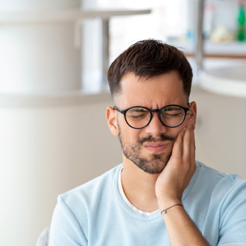 Man struggling with toothache at home