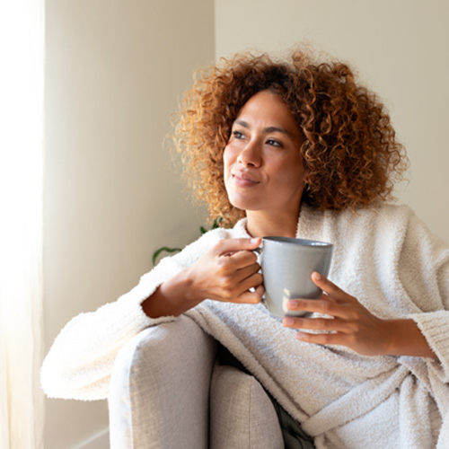 Woman relaxing on couch at home with tea