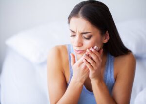 Woman having facial pain due to dental emergency