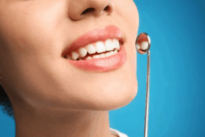 Close up of a woman’s smile and a dental mirror