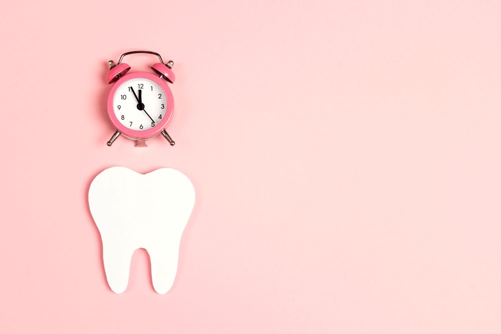 A photo of a tooth model and a clock