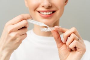 Woman using a professional teeth whitening kit
