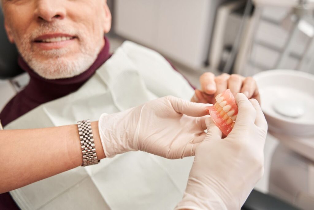A man discussing dentures with his dentist
